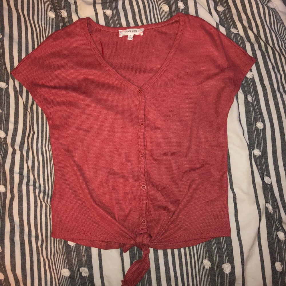 Pink button down shirt with a knot at the bottom